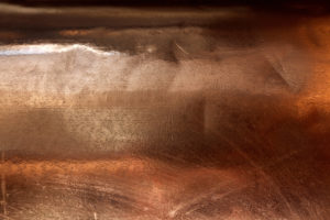 A close up of copper sheet metal showing various finishes